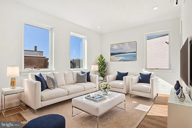a living room with furniture a rug a table and a window