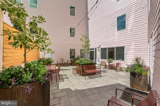 a view of backyard with outdoor seating and plants