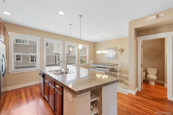 a open kitchen with a sink stove and wooden floor