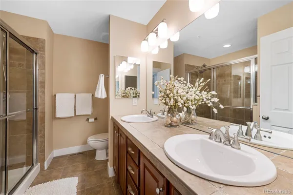 a bathroom with a double vanity sink mirror and toilet
