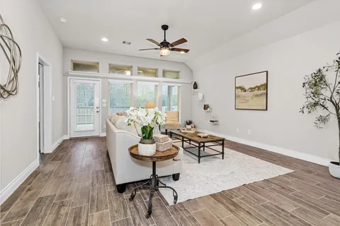 a living room with stainless steel appliances kitchen island granite countertop a stove a sink and a refrigerator