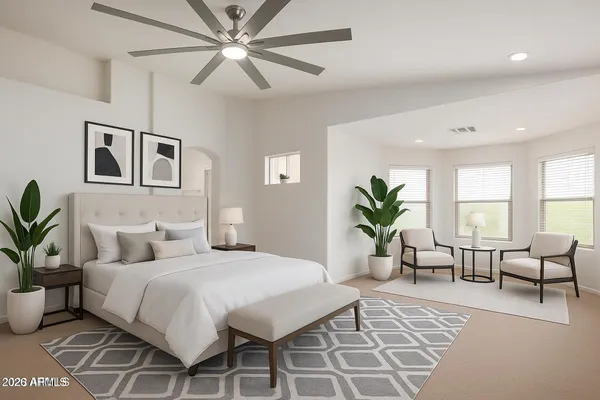 a bedroom with a large bed a rug and potted plant