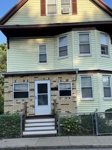 a view of a house with more windows and brick walls