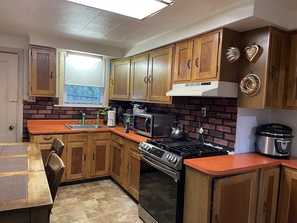 88 Alexander Street Boston, MA 02125 - Photo 10 of 17 a kitchen with stainless steel appliances granite countertop a stove a sink and a microwave