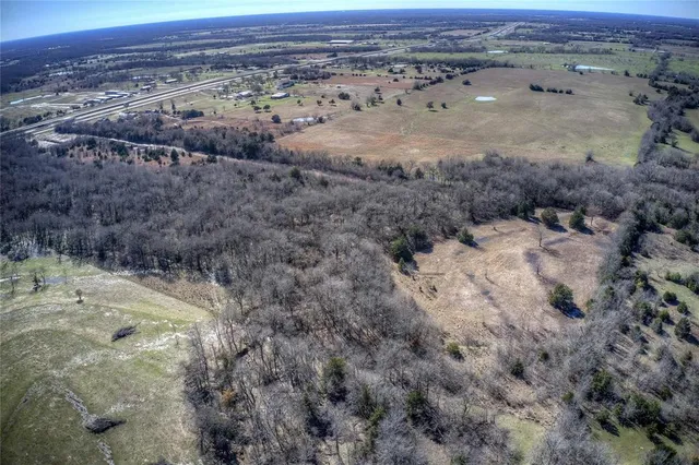 a view of a dry yard with wooden fence