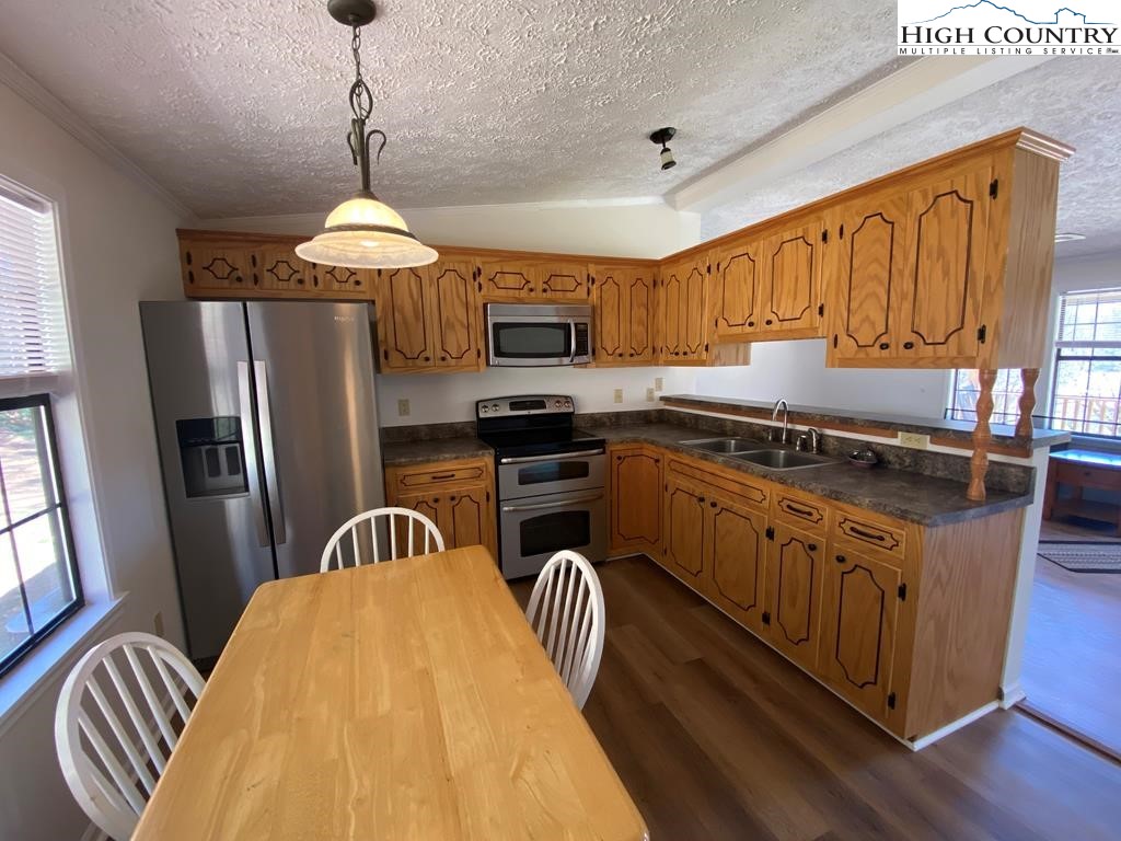 462 Hartsoe Road Warrensville, NC 28693 - Photo 5 of 17 a kitchen with stainless steel appliances granite countertop a sink dishwasher a refrigerator and a microwave