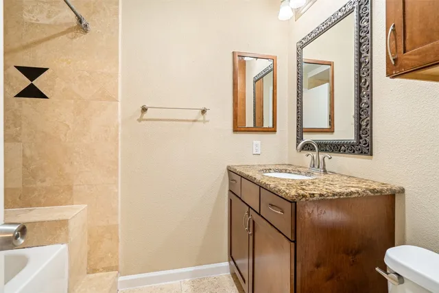 a bathroom with a granite countertop sink and a mirror