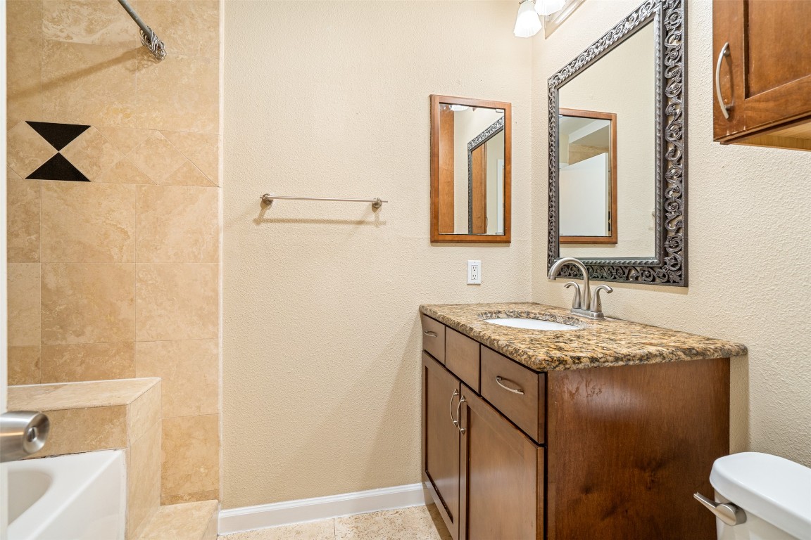505 Bellevue Place, Unit 3 Austin, TX 78705 - Photo 18 of 23 a bathroom with a granite countertop sink and a mirror