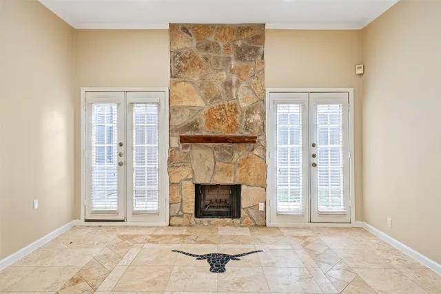 an empty room with fireplace and windows