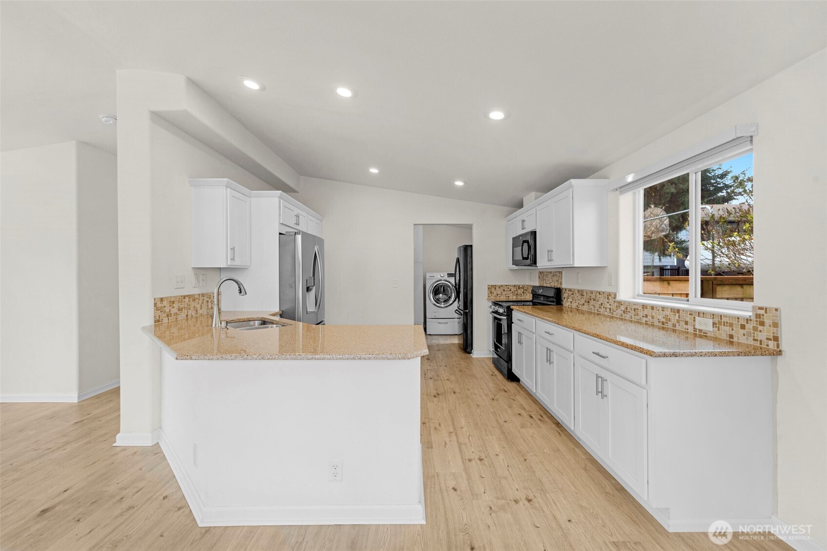3539 Southwest 100th Street Seattle, WA 98146 - Photo 11 of 32 a large kitchen with kitchen island a sink a counter and a large window
