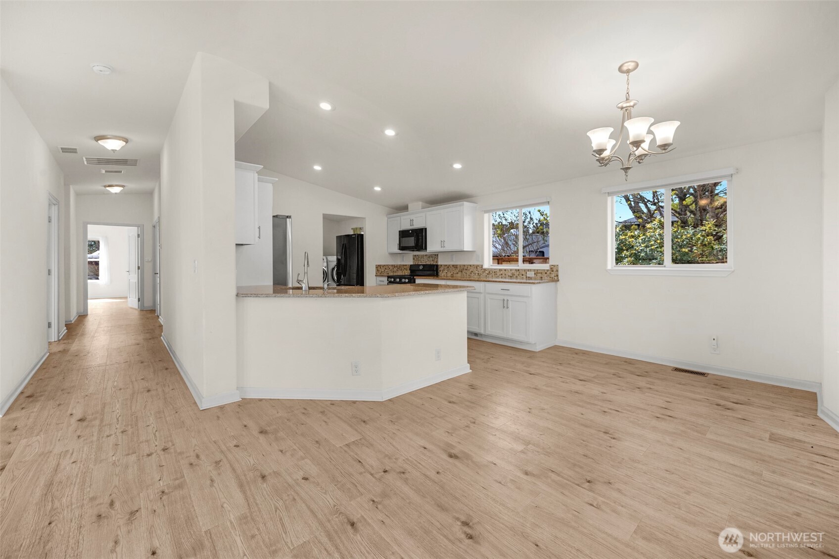 3539 Southwest 100th Street Seattle, WA 98146 - Photo 7 of 32 a view of a kitchen with kitchen island wooden floor center island and stainless steel appliances