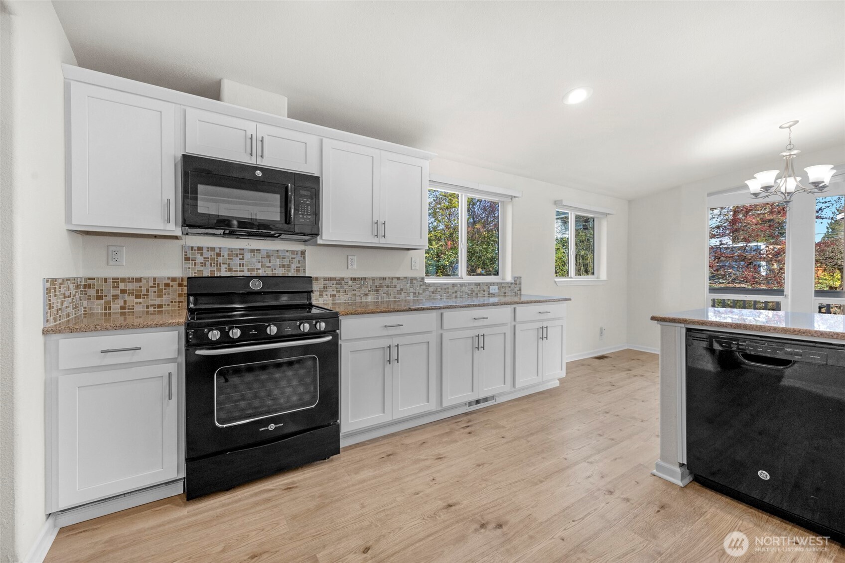 3539 Southwest 100th Street Seattle, WA 98146 - Photo 10 of 32 a kitchen with stainless steel appliances a stove sink microwave and cabinets