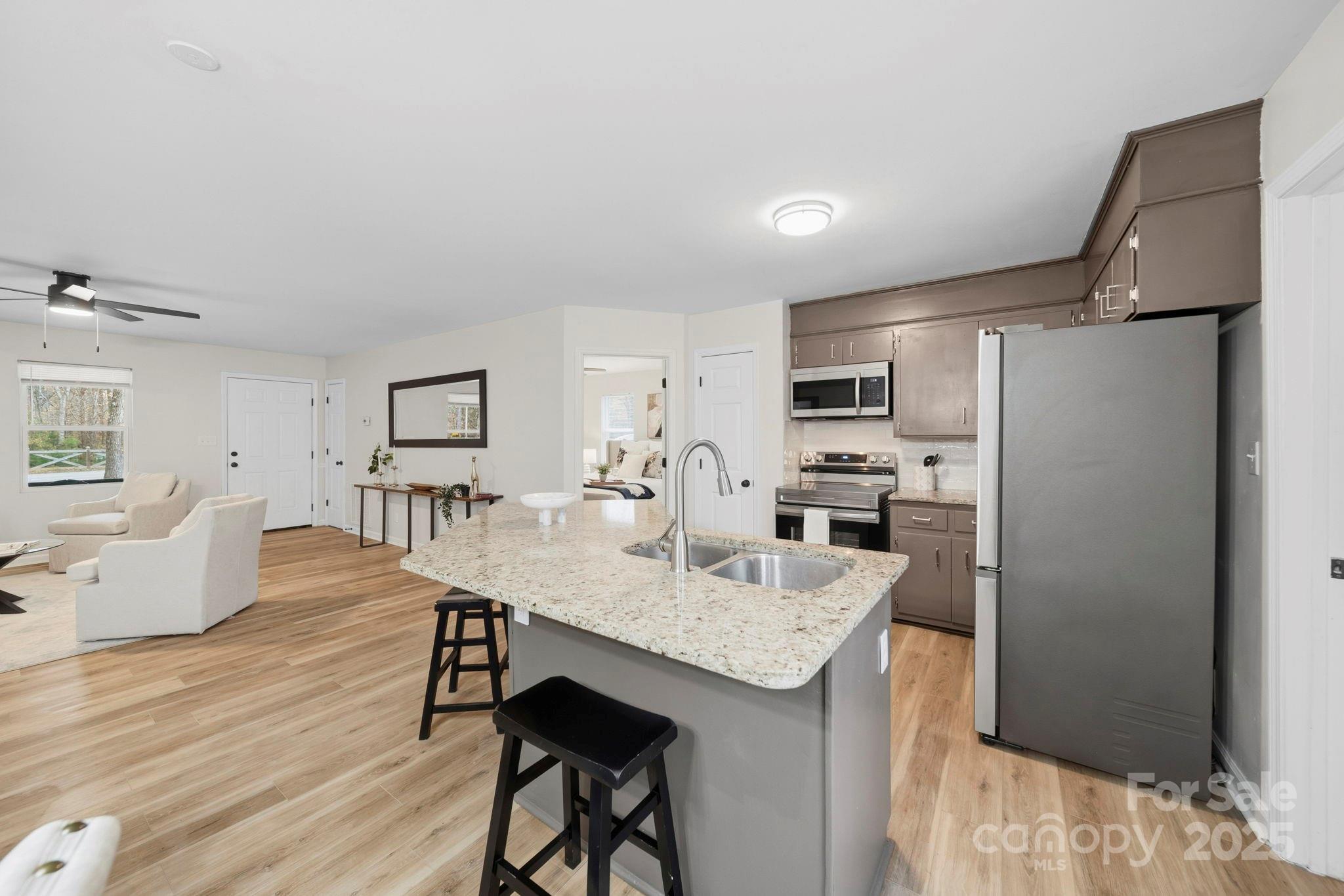 9329 Possum Hollow Road Fort Mill, SC 29707 - Photo 26 of 45 a kitchen with a refrigerator a stove cabinets and wooden floor