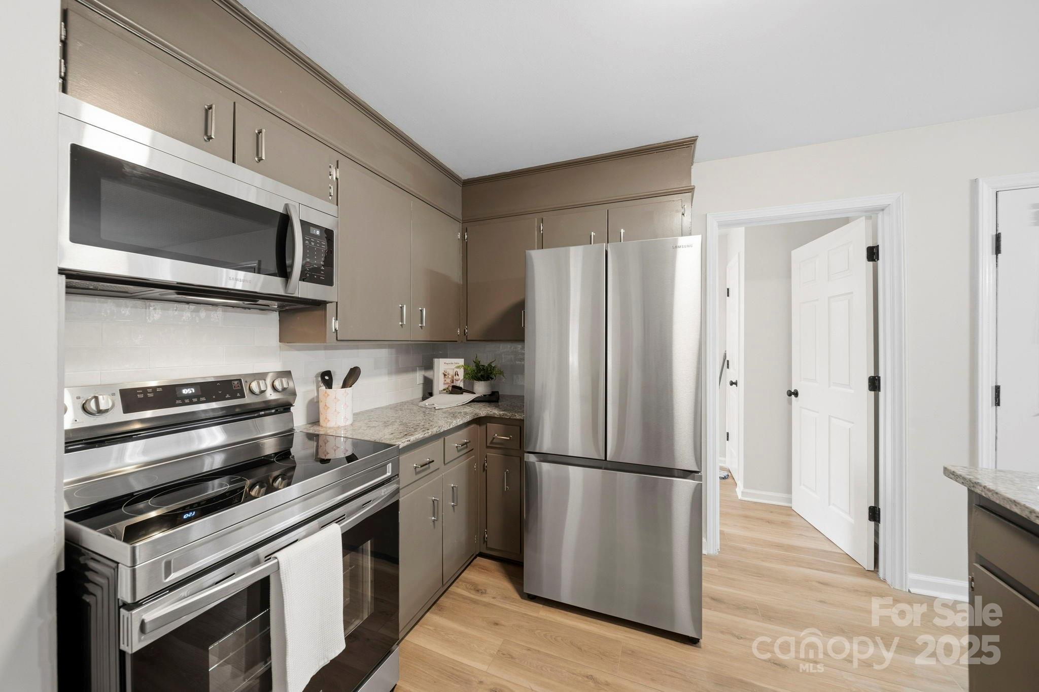 9329 Possum Hollow Road Fort Mill, SC 29707 - Photo 28 of 45 a kitchen with stainless steel appliances and wooden cabinets