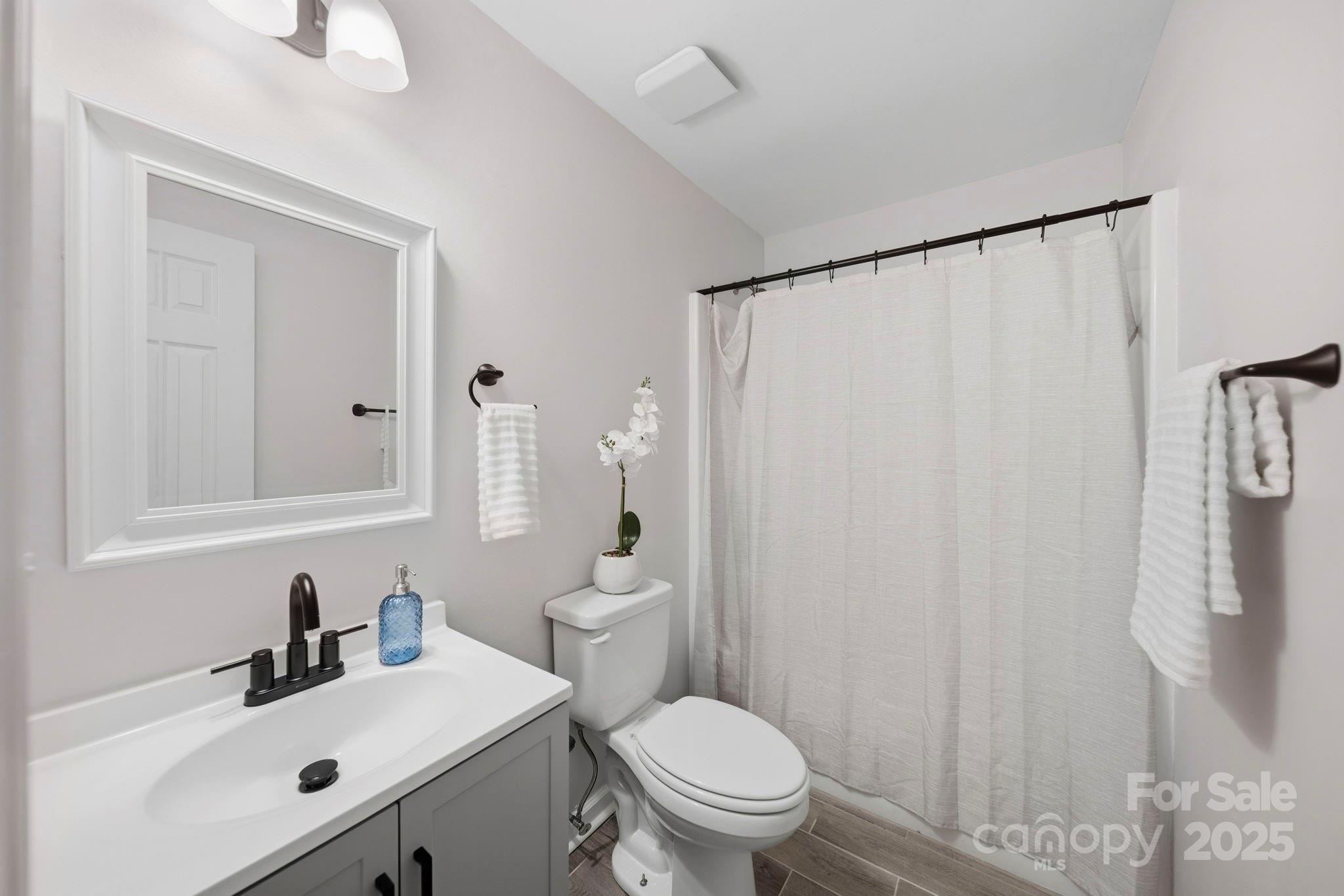 9329 Possum Hollow Road Fort Mill, SC 29707 - Photo 4 of 45 a bathroom with a sink a toilet and shower curtain