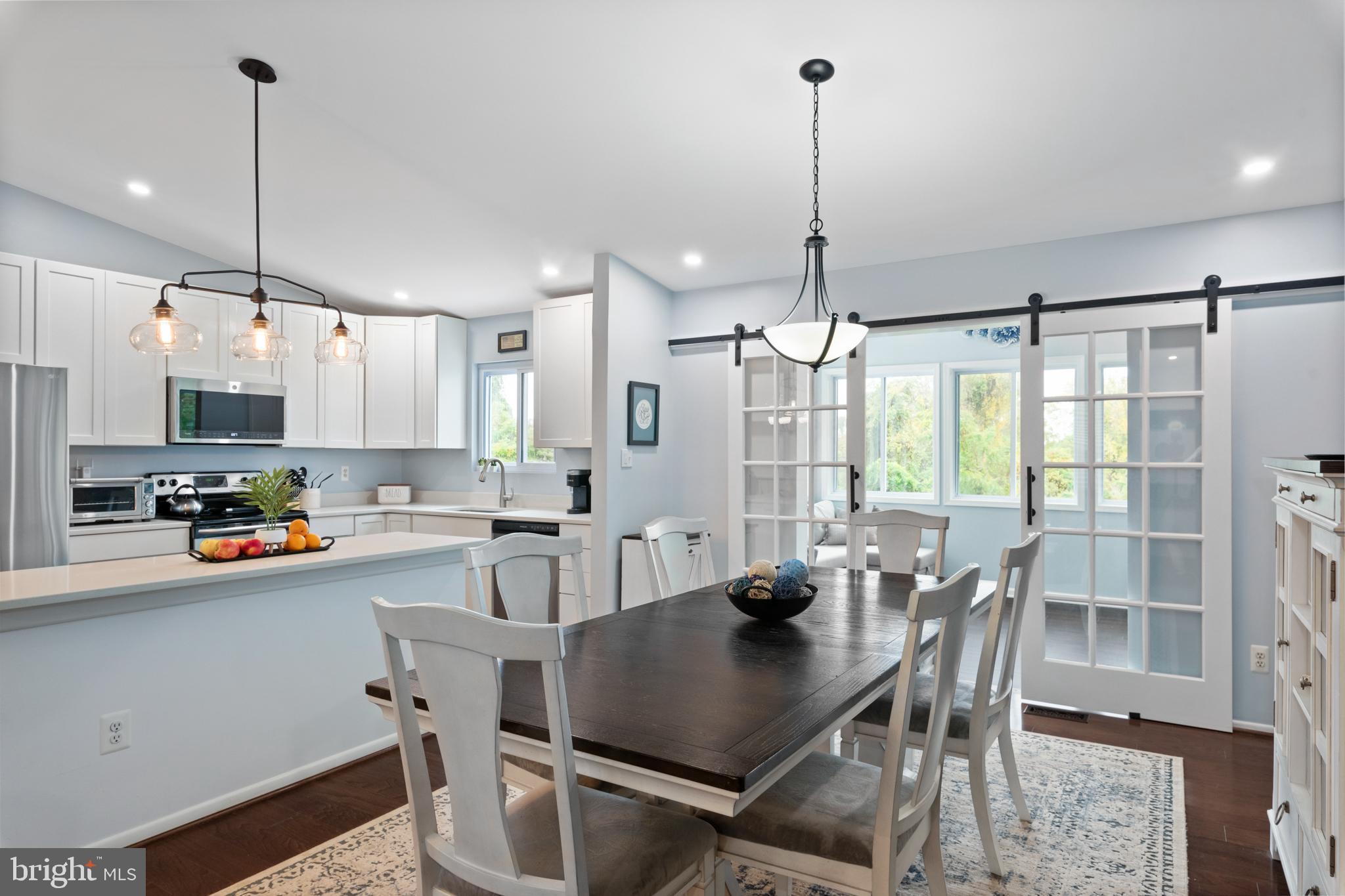 631 Truxton Road Annapolis, MD 21409 - Photo 17 of 61 a kitchen with stainless steel appliances a dining table chairs and white cabinets