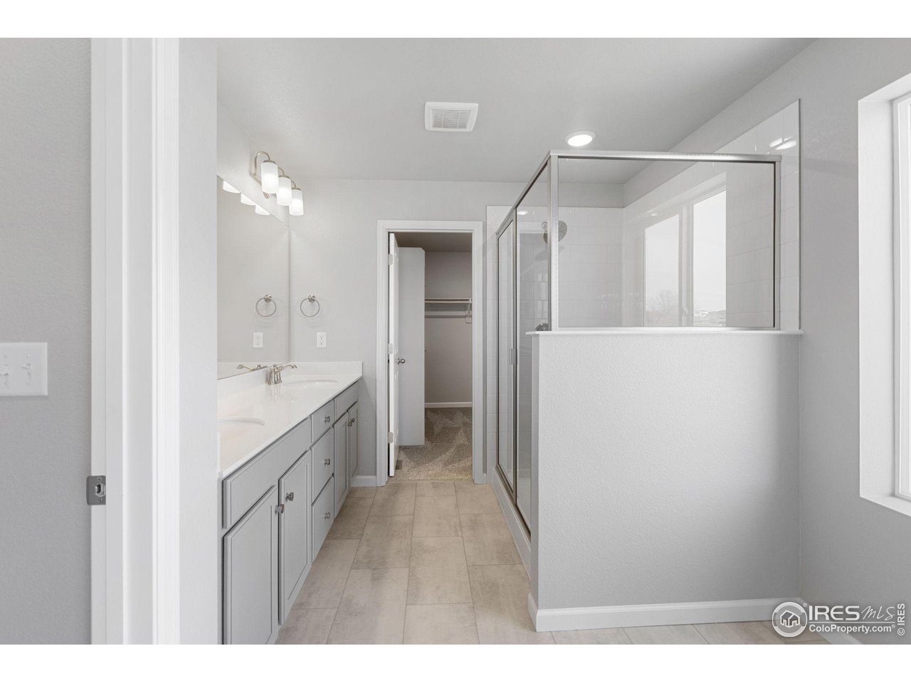 16953 Ballinger Circle Mead, CO 80542 - Photo 14 of 27 a bathroom with a double vanity sink a mirror and a shower