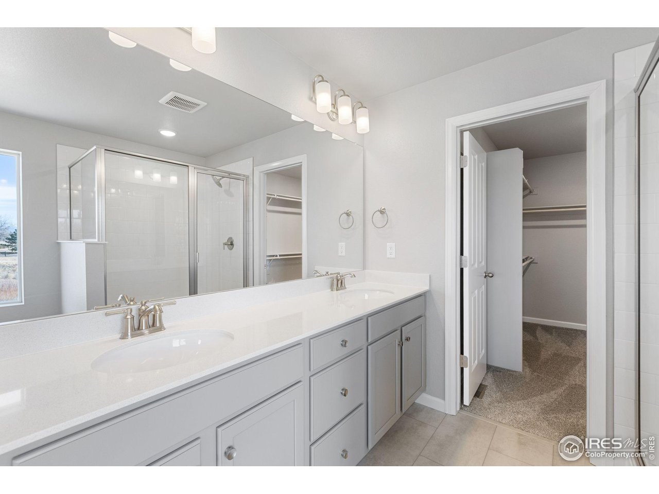 16953 Ballinger Circle Mead, CO 80542 - Photo 16 of 27 a bathroom with a double vanity sink and a mirror