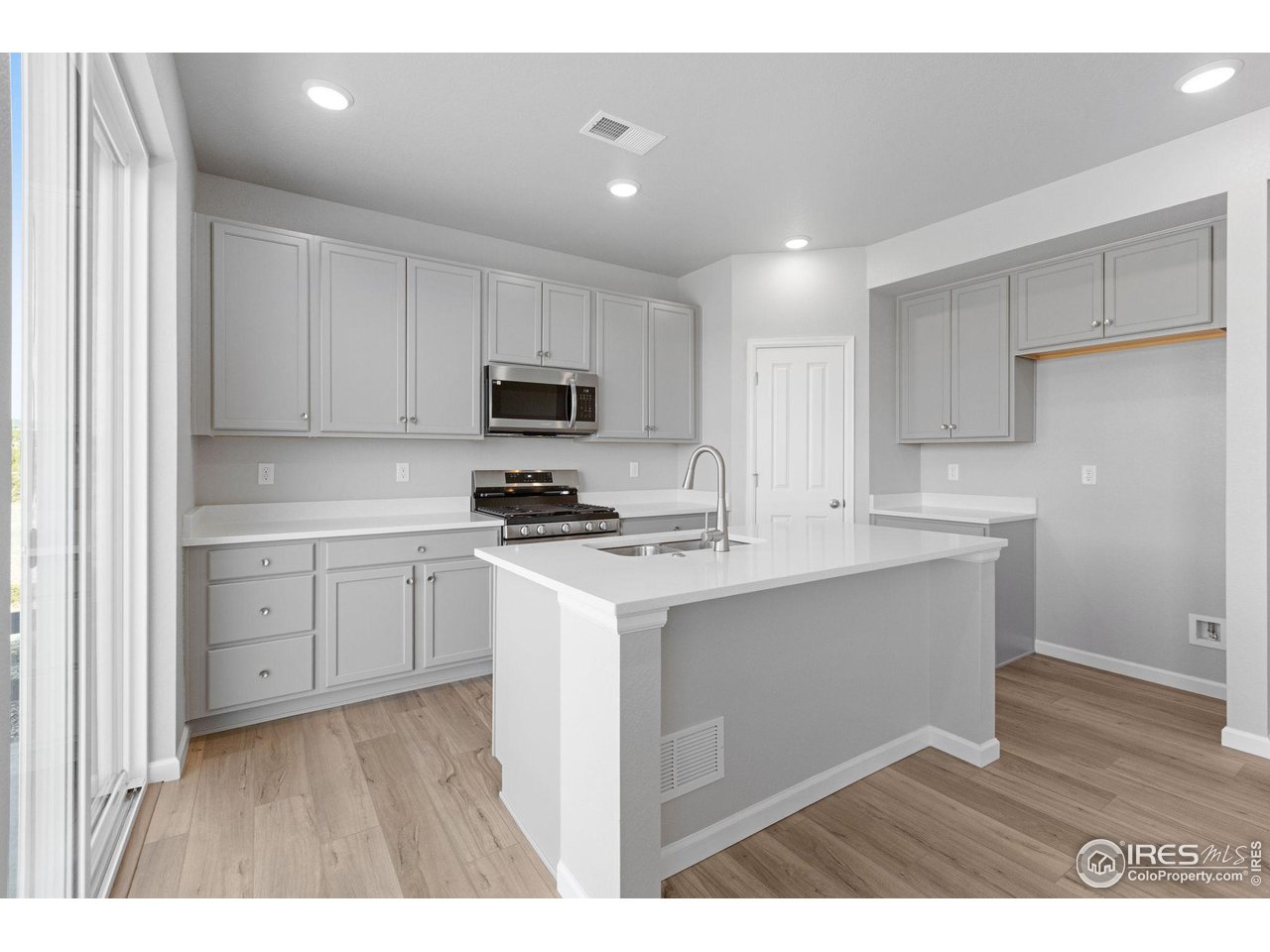 16953 Ballinger Circle Mead, CO 80542 - Photo 3 of 27 a kitchen with cabinets stainless steel appliances and wooden floor