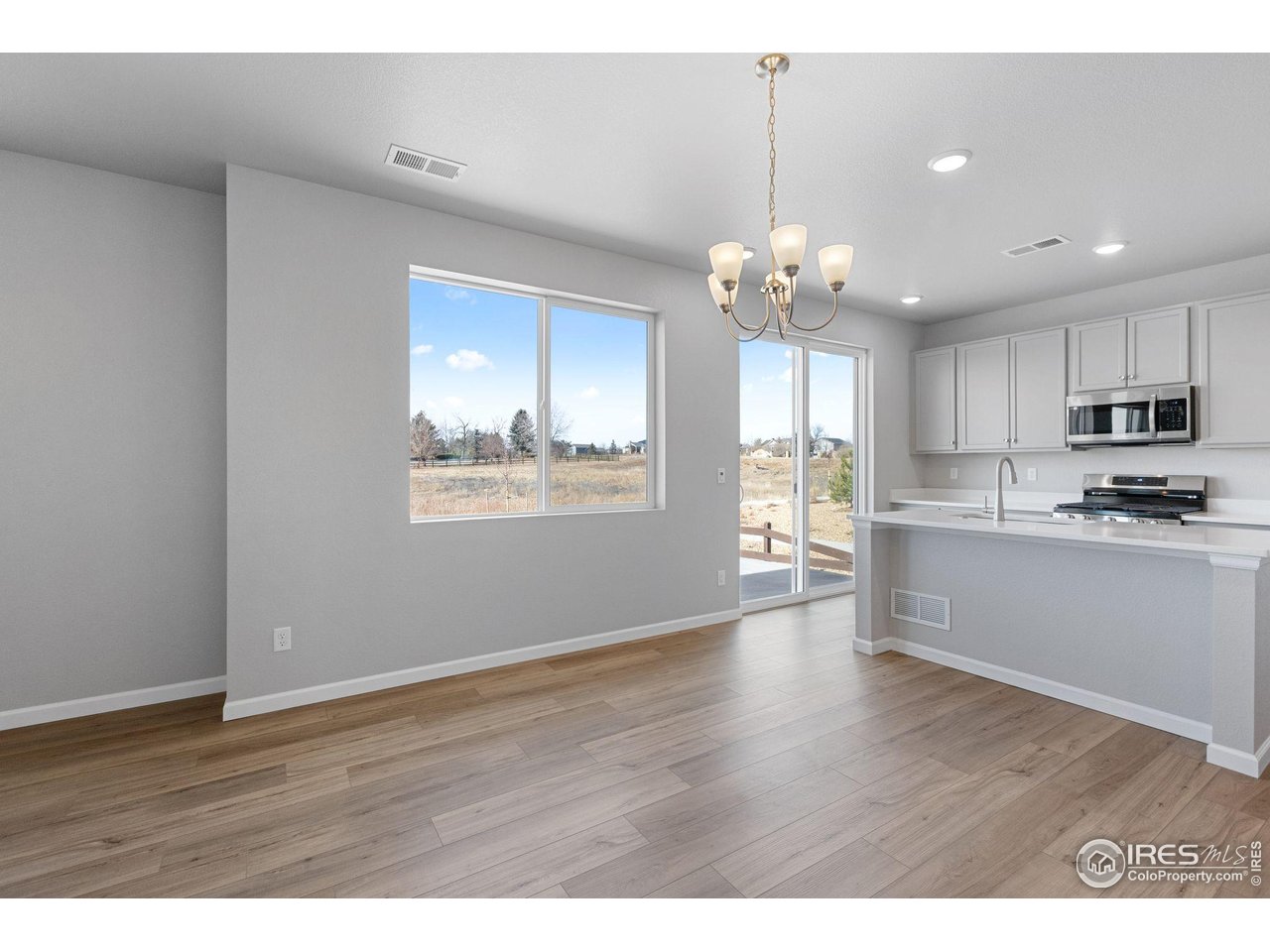 16953 Ballinger Circle Mead, CO 80542 - Photo 6 of 27 a view of an empty room with kitchen and window