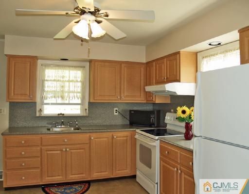 125 Normandy Road Colonia, NJ 07067 - Photo 4 of 10 a kitchen with a cabinets a chandelier and a window