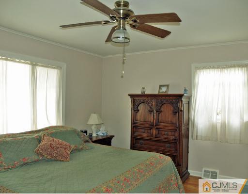 125 Normandy Road Colonia, NJ 07067 - Photo 5 of 10 a bedroom with a bed and a chandelier