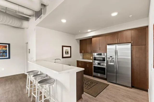 a kitchen with granite countertop a refrigerator and a stove top oven