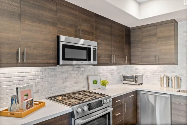 a kitchen with stainless steel appliances a stove sink and microwave