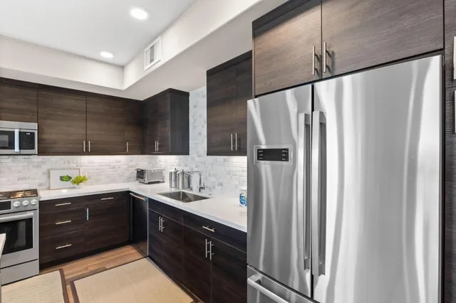 a kitchen with stainless steel appliances granite countertop a refrigerator and a sink
