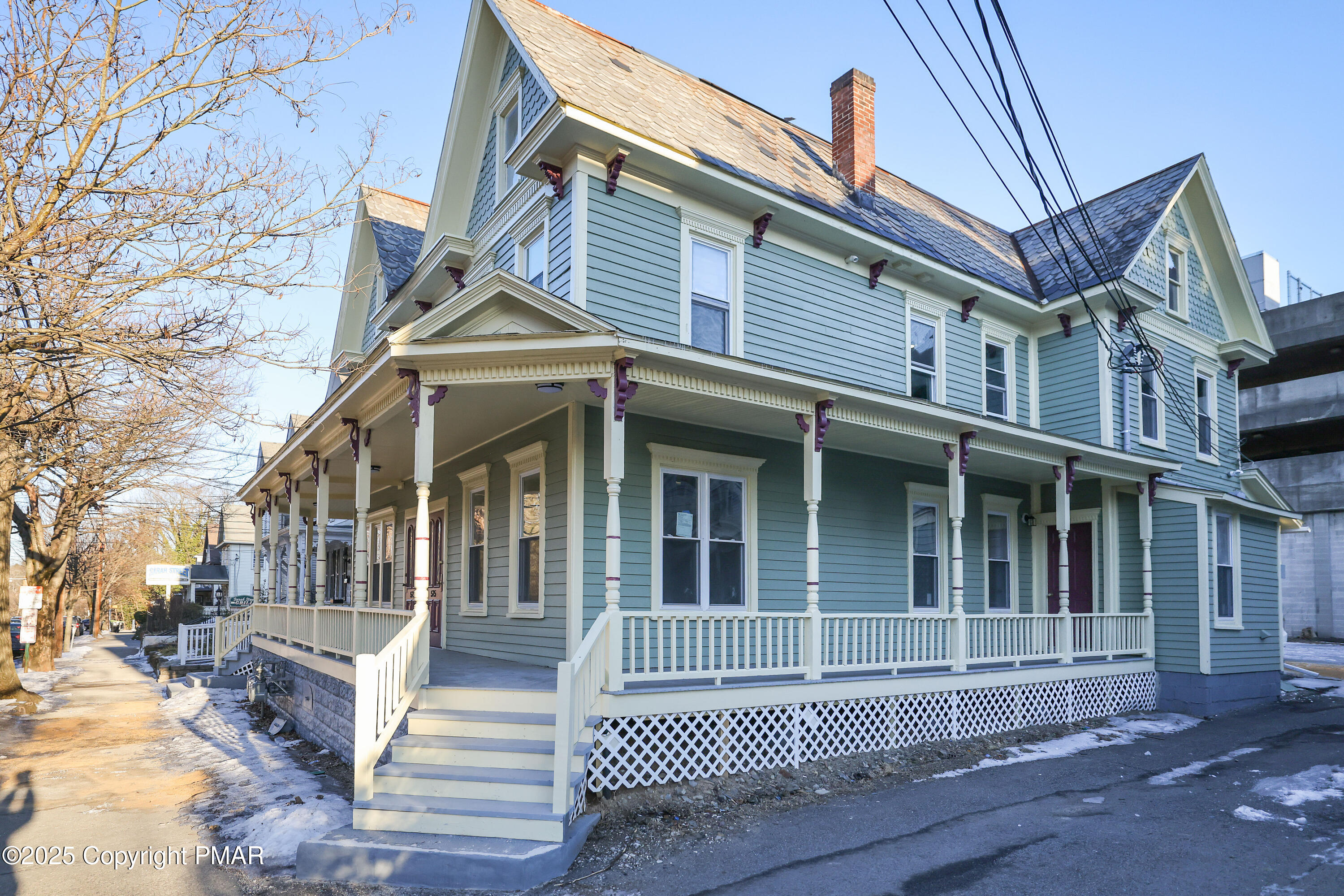 523 Sarah Street, Unit C Stroudsburg, PA 18360 - Photo 15 of 16 a view of a brick house with large windows and a small yard
