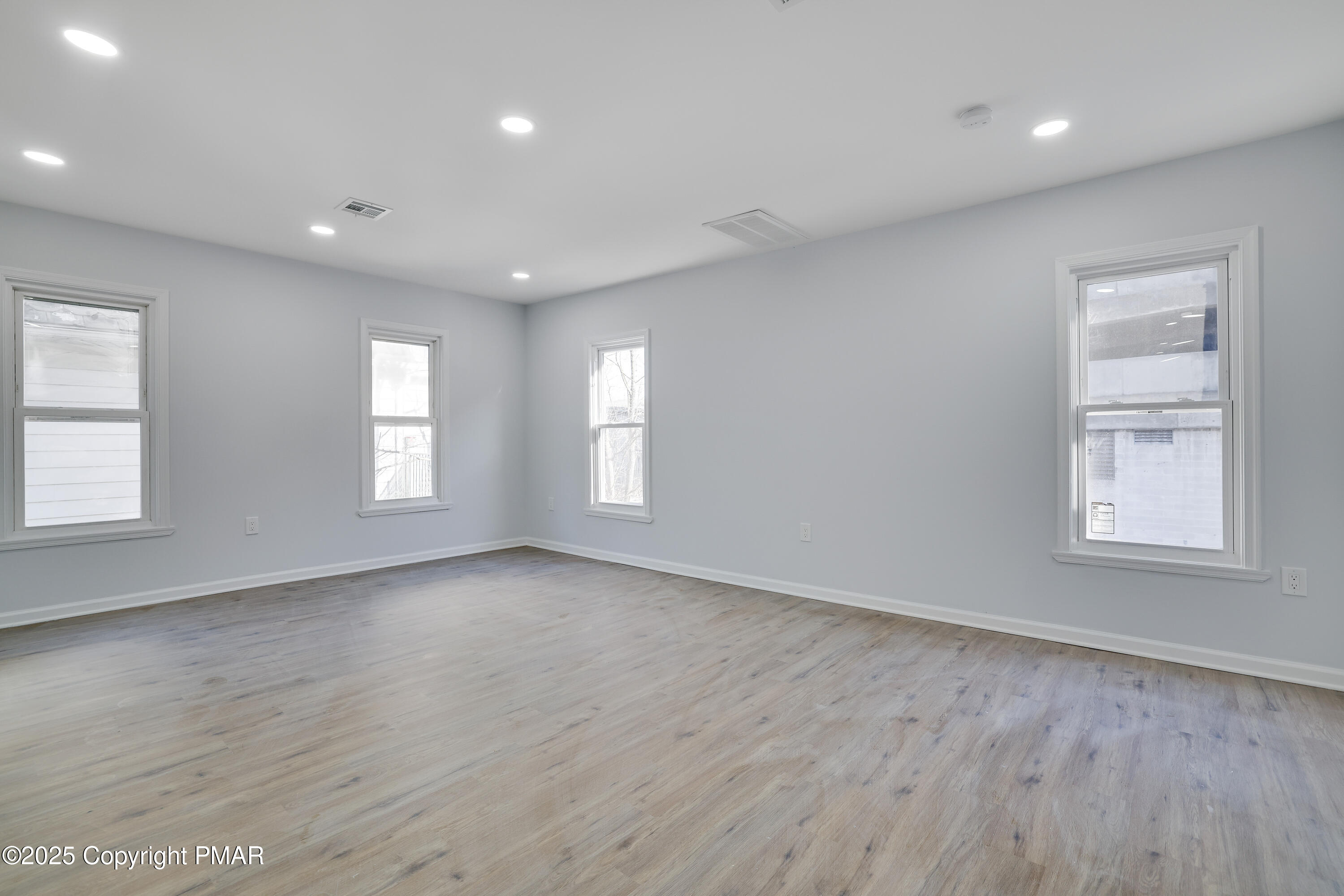 523 Sarah Street, Unit C Stroudsburg, PA 18360 - Photo 3 of 16 an empty room with wooden floor and windows