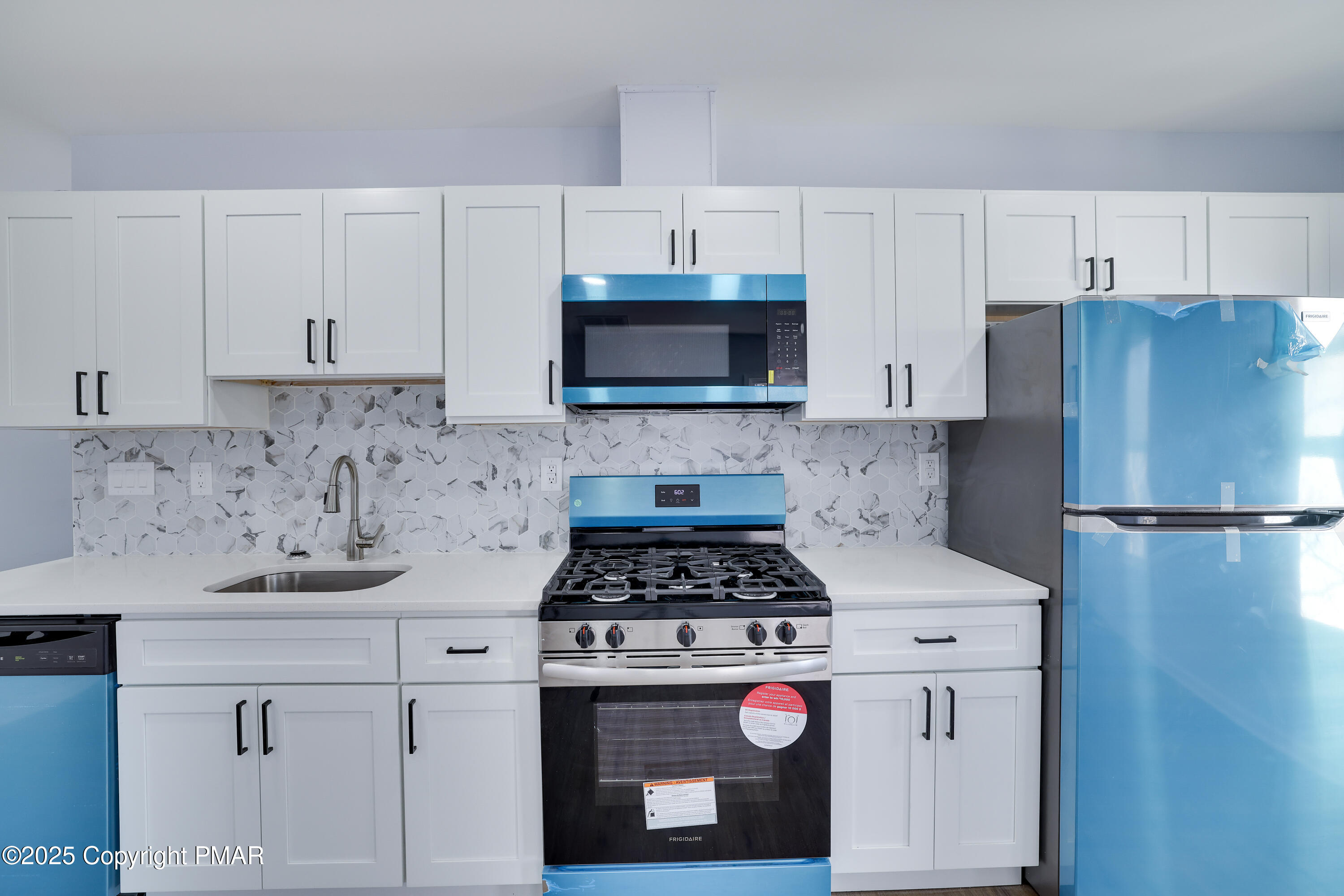 523 Sarah Street, Unit C Stroudsburg, PA 18360 - Photo 5 of 16 a kitchen with a refrigerator a stove a microwave and cabinets