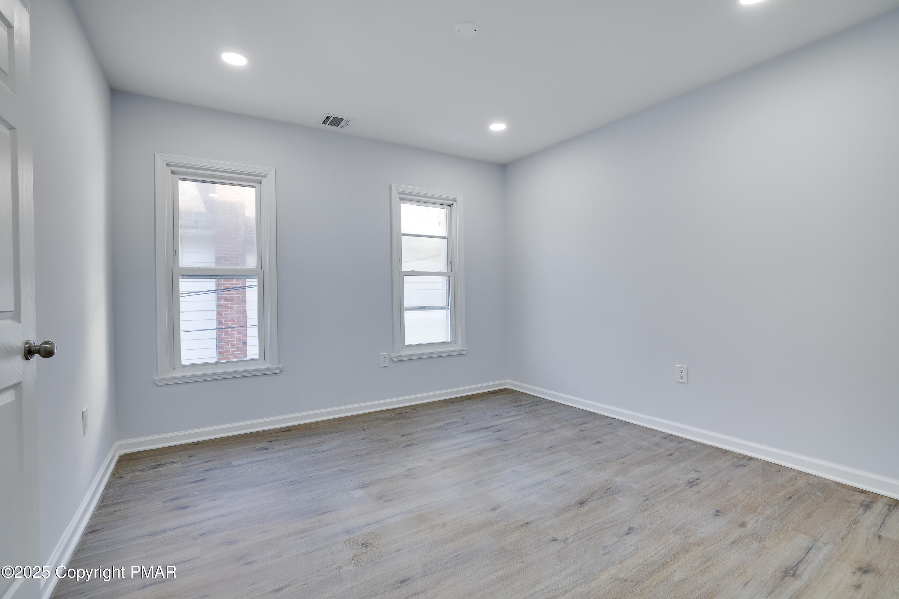 523 Sarah Street, Unit C Stroudsburg, PA 18360 - Photo 8 of 16 an empty room with wooden floor and windows
