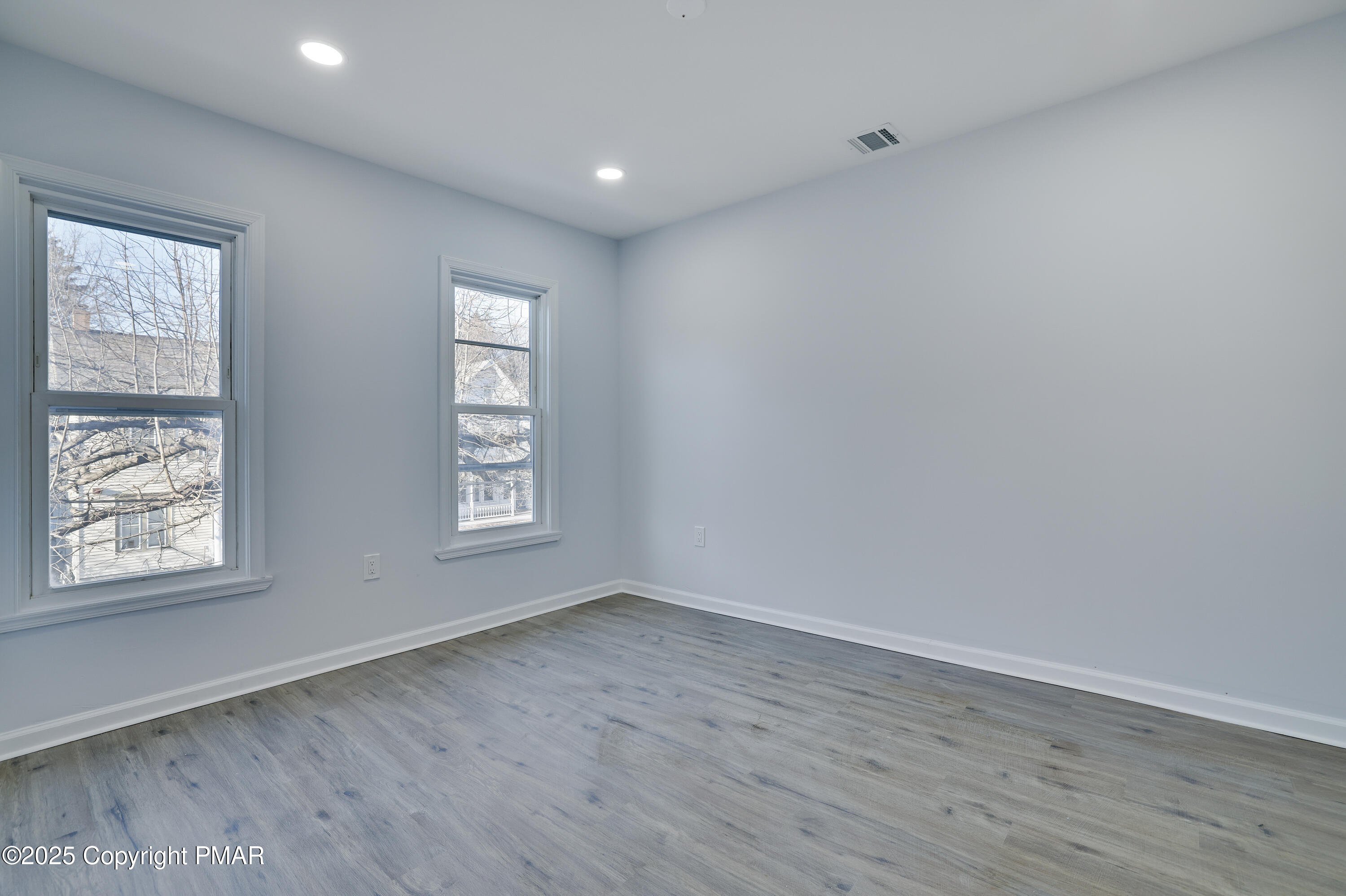 523 Sarah Street, Unit C Stroudsburg, PA 18360 - Photo 10 of 16 an empty room with wooden floor and windows