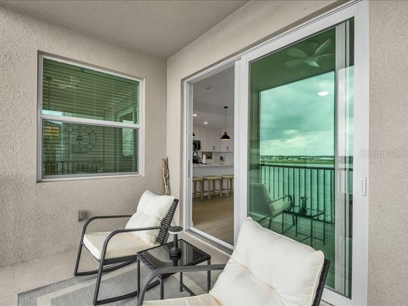 19116 Scallop Loop, Unit 303 Lakewood Ranch, FL 34211 - Photo 30 of 32 a living room with a large window and chairs