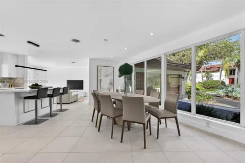 a dining room with furniture and large windows