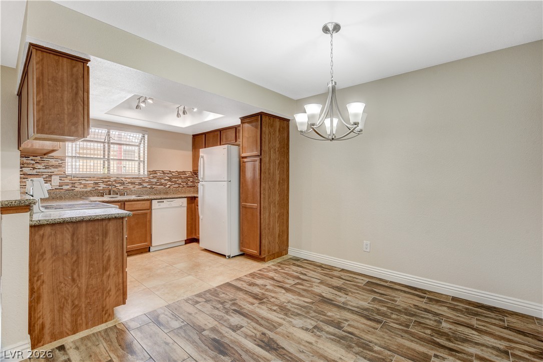 7200 West Pirates Cove Road, Unit 1026 Las Vegas, NV 89145 - Photo 9 of 35 This inviting kitchen and dining area features warm cabinetry and stylish flooring.