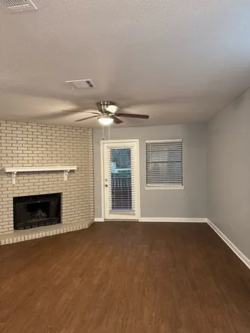 a view of an empty room with a fireplace and a window
