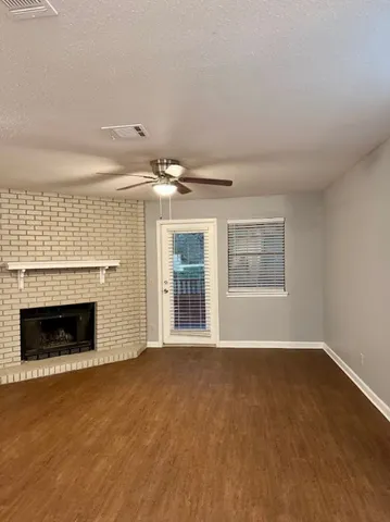 a view of an empty room with a fireplace and a window
