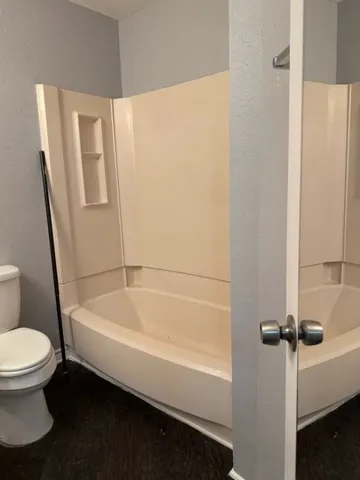 a bathroom with a white toilet and a bathtub