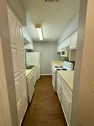 a kitchen with cabinets and white appliances