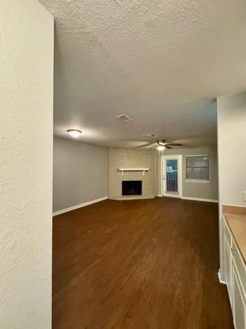 an empty room with windows and fireplace