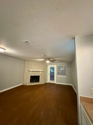 an empty room with windows and fireplace