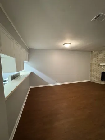 a view of an empty room with a fireplace and a window