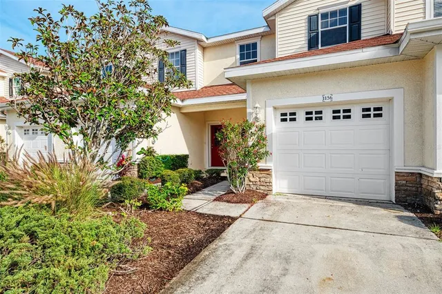 a vase with flowers sitting on a floor in front of a door