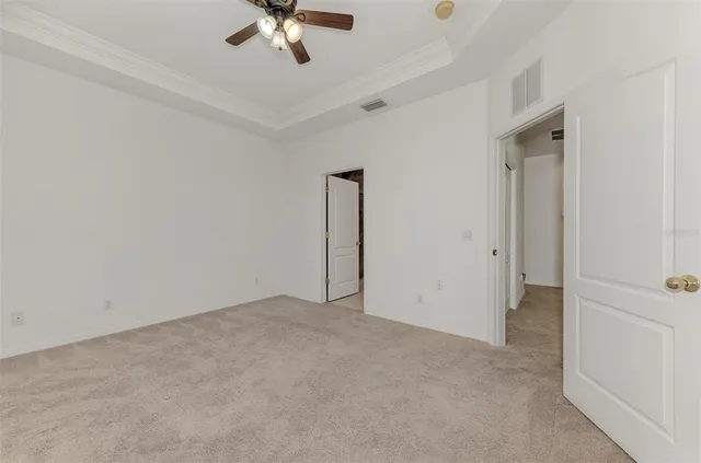 an empty room with a window and a ceiling fan