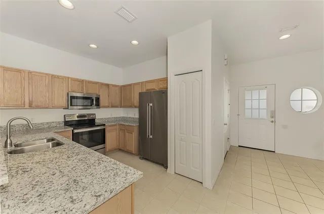 a kitchen with granite countertop a sink stainless steel appliances and cabinets