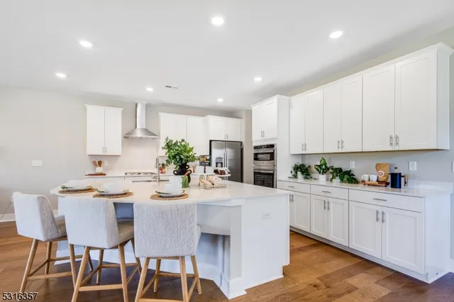 a kitchen with a dining table chairs and white cabinets