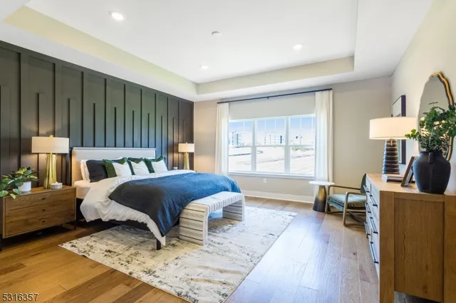 a bedroom with a bed wooden floor and lamp