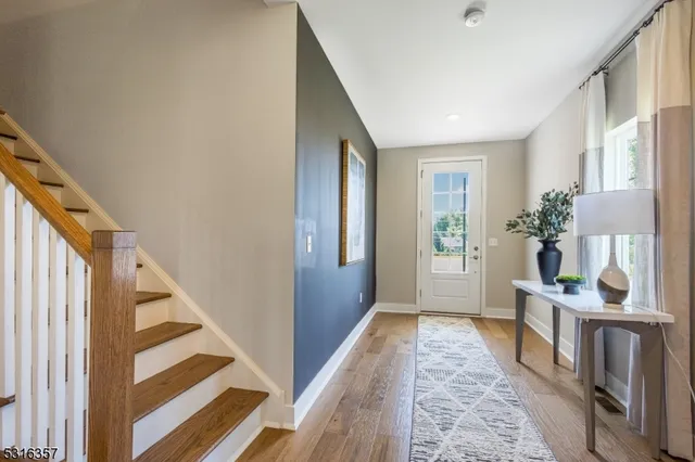 a view of an entryway with wooden floor and a livingroom view